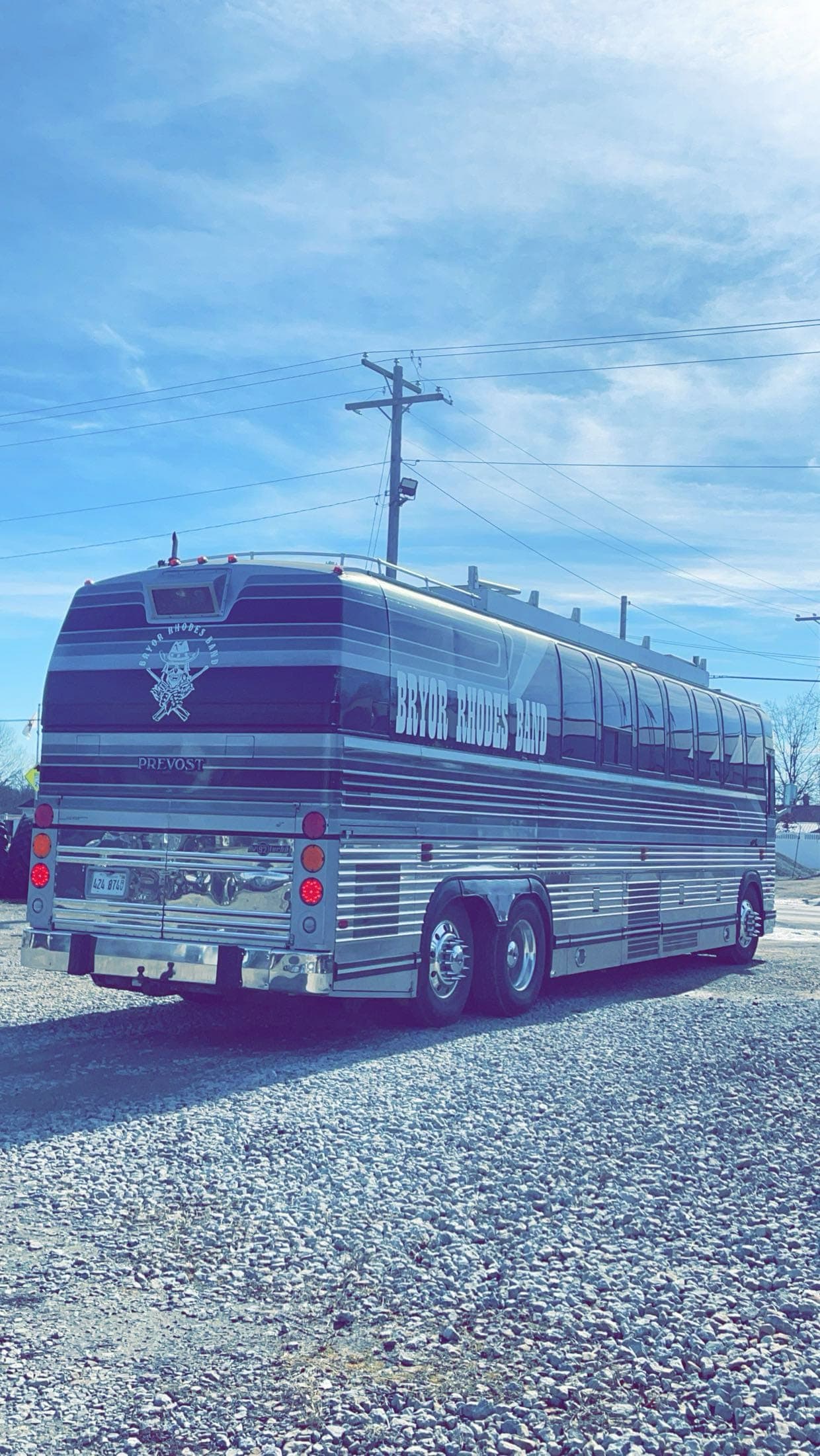 The band by the tour bus during the day